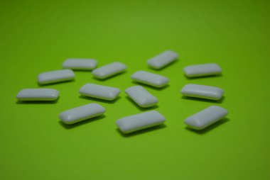 Yeşil kağıdın üzerinde beyaz sakız yastıkları var..