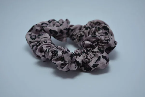 Female purple hair elastic band with black dots on a white background.