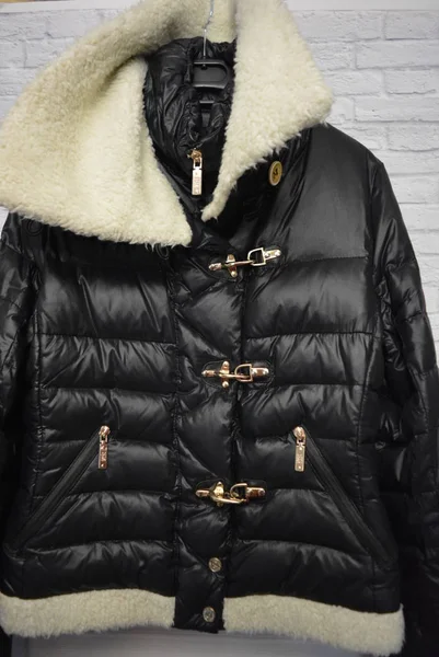 Black stylish women\'s down winter jacket with white fur, a substitute with a gold forniture