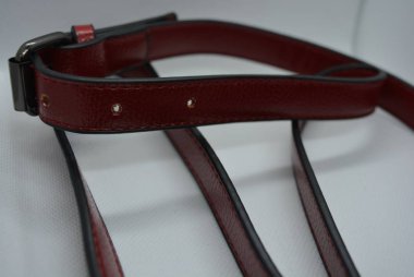 Kiraz kırmızısı kemer, beyaz kumaş fotoğraf arka plan üzerinde metal karabina ile orijinal derisi deri kayış.