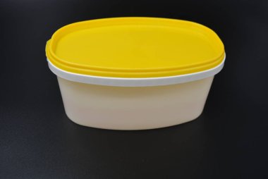 Gıda ve mayonez şık siyah bir zemin üzerine sarı kapaklı Beyaz Plastik Konteyner