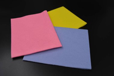 Kuru ve ıslak temizlik için renkli yeni paçavra sarı, mor ve pembe sağlık ve mat siyah bir arka plan üzerinde ev temizliği için