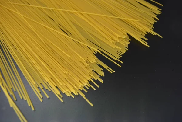 Long dry vermicelli, Italian pasta spaghetti from hard wheat varieties in packs on an interesting black background