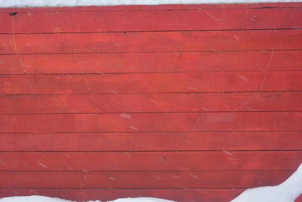 Red knocked wooden boxes made of white sand with white fluffy snow and white snowflakes