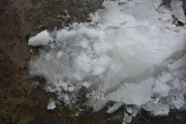 Güzel kar arka plan, beton bir yapı üzerinde eriyen kar, gri-kahverengi renkli beton duvar.