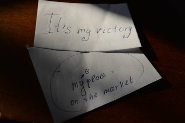 Kâğıt üzerindeki yazıt, piyasadaki yerim ve ahşap lake masadaki bir sürü kağıtla benim zaferim.