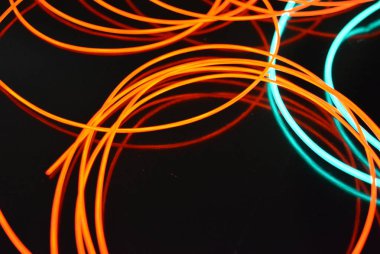 Neon yeşil ivedi ve kırmızı ince tel. Işıklı teller, dekorasyon ve yüzey aydınlatma. Elektrolüminesans tel, aydınlatma nesneleri ve ışık tabanı.