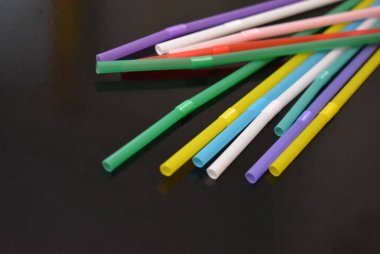 Alkol ve içecekler için kokteyl plastik tüpler, yansıtıcı siyah yüzey üzerinde renkli. Otel ve bar iş, eğlence ve eğlence için şeyler.