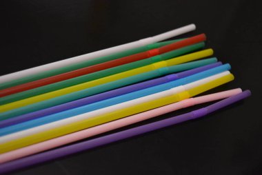 Alkol ve içecekler için kokteyl plastik tüpler, yansıtıcı siyah yüzey üzerinde renkli. Otel ve bar iş, eğlence ve eğlence için şeyler.