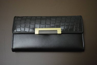 Siyah deri cüzdan, mat kahverengi bir arka plan üzerinde bulunan orijinal derisi deri kadın cüzdanı. Para ve finans, cüzdanında para biriktirme. Şık kadın aksesuar, finans ve bankacılık.