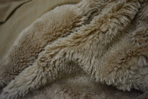 Soft coffee synthetic fabric in the form of natural long fur. Brown synthetic fur in spacing arrangement with different structure and shape.