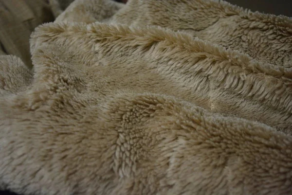 Soft coffee synthetic fabric in the form of natural long fur. Brown synthetic fur in spacing arrangement with different structure and shape.