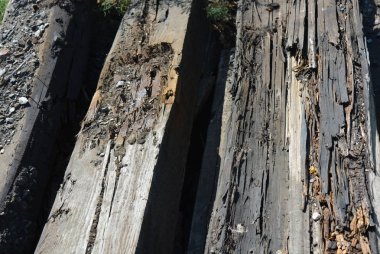 Demiryolu hattından eski siyah ve kahverengi ahşap çubuklar, kırık ve zaman kırık. Güneş ışığı altında alışılmadık renk ile çok benzersiz ahşap arka plan.