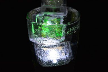 Parlayan buz küpleri ile içecekler çok güzel ve çarpıcı görüntüler. Şampanya bir bardak kabarcıklar ile parlak renkler. Rahatlatıcı, sevgili yaşam ve lezzetli bir köpüklü içecek Promosyon görüntü.