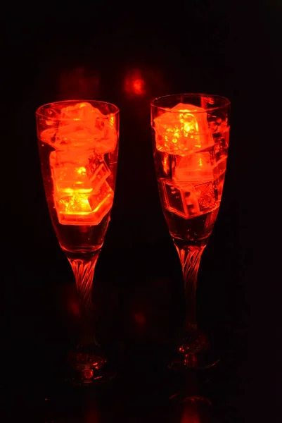 Çkili Iki Sıradışı Şampanya Parlak Kırmızı Buz Parçaları Siyah Bir — Stok fotoğraf
