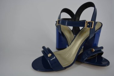 Doğal patent deri ve zotoli tabanlık zarif kadın sandalet. Bir süpürge ve altın tokaile yüksek, geniş topuklu şık koyu mavi sandalet.