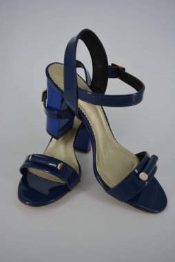 Doğal patent deri ve zotoli tabanlık renkli zarif kadın sandalet. Bir süpürge ve altın tokaile yüksek, geniş topuklu şık koyu mavi sandalet.