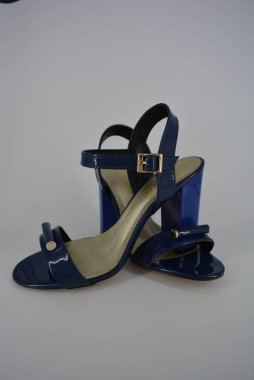 Doğal patent deri ve zotoli tabanlık renkli zarif kadın sandalet. Bir süpürge ve altın tokaile yüksek, geniş topuklu şık koyu mavi sandalet.