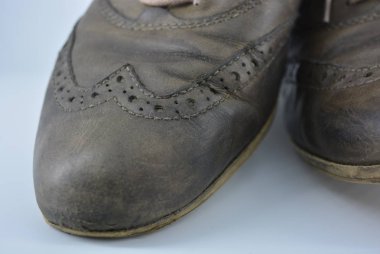 Kadın alışılmadık gri kahverengi ayakkabı, İngiliz tarzı hakiki deri ayakkabı. Yıpranmış deri ve özel renklere sahip aristokrat ve antika ayakkabılar beyaz bir arka plan üzerinde yer almaktadır.