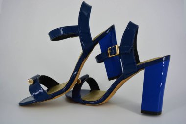 Doğal patent deri ve zotoli tabanlık renkli zarif kadın sandalet. Bir süpürge ve altın tokaile yüksek, geniş topuklu şık koyu mavi sandalet.