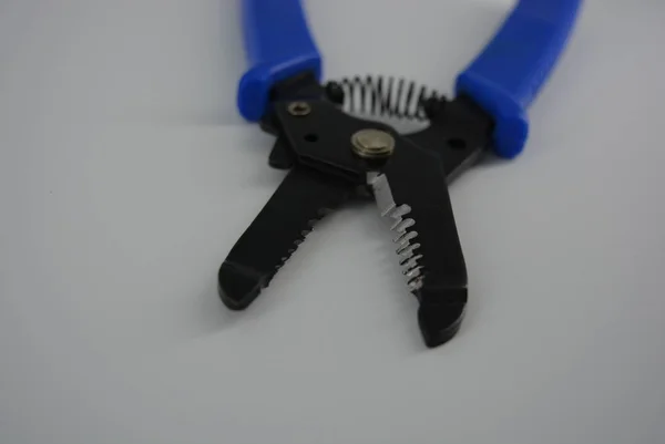 用于从钢丝中剥离绝缘的多功能装置 用于剥离电缆和电线的手动工具 白色背景上带有蓝色手柄的切碎器 — 图库照片