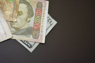 Usd 20 $ yirmi Amerikan doları ve Uah 100 yüz Ukrayna Grivnası kahverengi mat arka plan üzerinde boyutukağıt faturaları. Ukrayna ve Amerikan para birimleri, ödemeler ve nakit ödemeler.