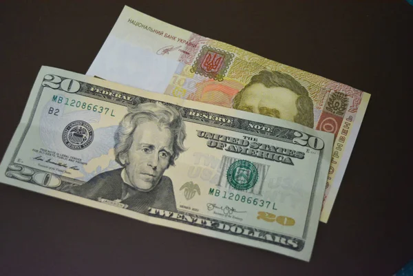 Usd 20 $ yirmi Amerikan doları ve Uah 100 yüz Ukrayna Grivnası kahverengi mat arka plan üzerinde boyutukağıt faturaları. Ukrayna ve Amerikan para birimleri, ödemeler ve nakit ödemeler.