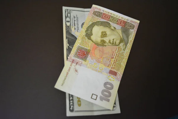 Usd 20 $ yirmi Amerikan doları ve Uah 100 yüz Ukrayna Grivnası kahverengi mat arka plan üzerinde boyutukağıt faturaları. Ukrayna ve Amerikan para birimleri, ödemeler ve nakit ödemeler.