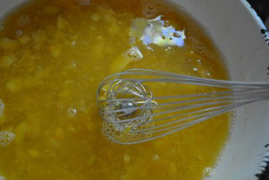 Metal kitchen whisk in a fruit apricot broth, a kampot from fresh apricot for fruit jelly/