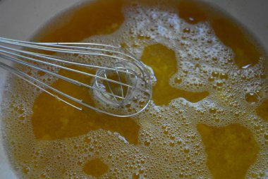 Metal kitchen whisk in a fruit apricot broth, a kampot from fresh apricot for fruit jelly/