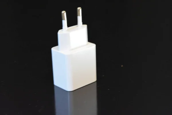 Usb 连接器的白色插头 用于从 220 伏电源为手机充电 位于光滑的黑色表面上 — 图库照片