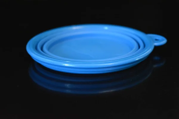 蓝色折叠和多功能橡胶板 黑色光泽表面上带有塑料边缘的碗 — 图库照片