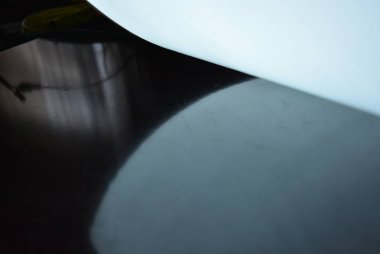 Elektrolüminesans kaplamaya sahip Parlak A4 kağıt, el değmemiş parlak bir yüzey üzerinde farklı düzlemlerde yer alır. Mükemmel renk arka plan, renk substrat, düzgün parlaklık.