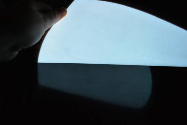 Bir kaplama ile çok parlak ve parlak A4 elektrolüminesans kağıt bir kadın eli ile bozulmamış parlak yüzeyüzerinde farklı düzlükler yer almaktadır. Mükemmel renk substrat, düzgün parlaklık.