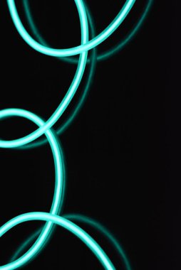 Geceleri parlayan turkuaz renkli malzemeden yapılmış sıradışı parlak teller. Kaotik gökyüzü mavitelleri, ışık kılavuzu elektrolüminesans telleri, elektrolüminesans parlak siyah bir yüzey üzerinde yer alır.