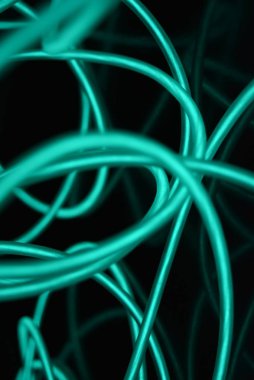 Geceleri parlayan turkuaz renkli malzemeden yapılmış sıradışı parlak teller. Kaotik gökyüzü mavitelleri, ışık kılavuzu elektrolüminesans telleri, elektrolüminesans parlak siyah bir yüzey üzerinde yer alır.