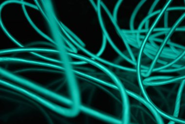 Geceleri parlayan turkuaz renkli malzemeden yapılmış sıradışı parlak teller. Kaotik gökyüzü mavitelleri, ışık kılavuzu elektrolüminesans telleri, elektrolüminesans parlak siyah bir yüzey üzerinde yer alır.