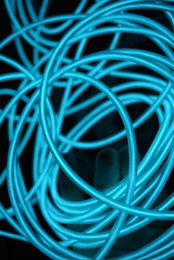 Geceleri parlayan turkuaz renkli malzemeden yapılmış sıradışı parlak teller. Kaotik gökyüzü mavitelleri, ışık kılavuzu elektrolüminesans telleri, elektrolüminesans parlak siyah bir yüzey üzerinde yer alır.