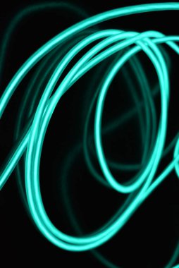 Geceleri parlayan turkuaz renkli malzemeden yapılmış sıradışı parlak teller. Kaotik gökyüzü mavitelleri, ışık kılavuzu elektrolüminesans telleri, elektrolüminesans parlak siyah bir yüzey üzerinde yer alır.