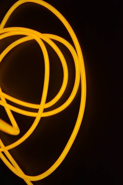 Parlak turuncu parlak tel, bükülmüş ışık teli, kablo. Farklı bükümler, sulu el tel ile lectroluminesans tellerin farklı şekil ve görüntüleri.