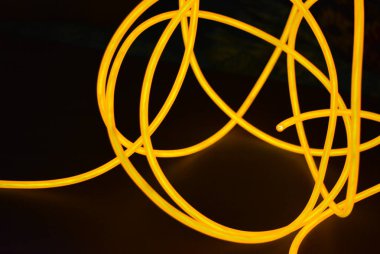 Parlak turuncu parlak tel, bükülmüş ışık teli, kablo. Farklı bükümler, sulu el tel ile lectroluminesans tellerin farklı şekil ve görüntüleri.