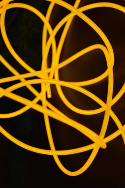 Parlak turuncu parlak tel, bükülmüş ışık teli, kablo. Farklı bükümler, sulu el tel ile lectroluminesans tellerin farklı şekil ve görüntüleri.