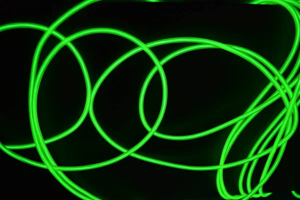 具有不同形状和结构的有毒绿色发光电致发光线 石灰电致发光纤维网 线和异常圆 位于黑色光泽表面上 — 图库照片