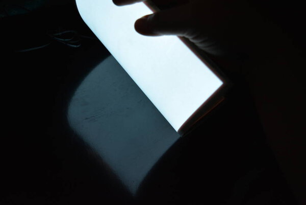 Очень яркая и светящаяся электролюминесцентная бумага А4 с покрытием расположена в разных плоскостях на нетронутой глянцевой поверхности с женской рукой. Отличный цвет подложки, равномерное свечение
.