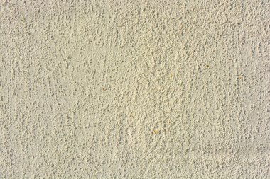 İş, inşaat ve onarım malzemeleriyle yüzleşmek. Güneş ışığının altında küçük yapısal topların olduğu beyaz duvar. Bu arkaplanın ilginç bir yapısı ve dokusu.