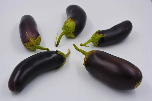 Fresh blue, purple eggplants recently picked and arranged on a matte white background. Delicious vegetables that grow in Ukraine, healthy and wholesome food for every day.