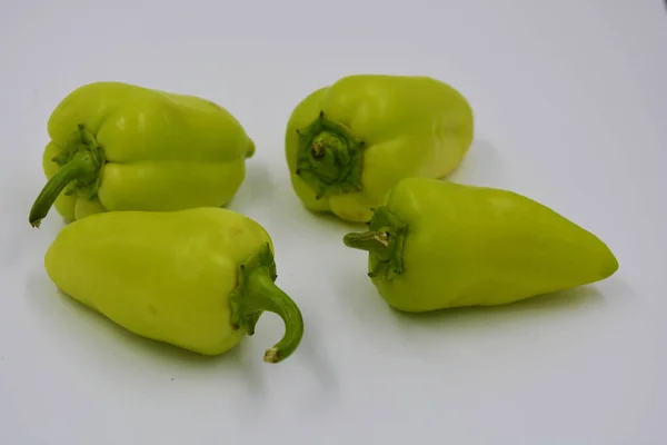 Fresh yellow and green bell peppers, not hot sad peppers are arranged on a white background. Vegetables that grow in Ukraine, healthy and wholesome food for every day.