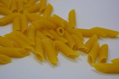 İtalyan sarısı makarna, erişte makarna, beyaz arka plana saçılmış buğday tüyü..