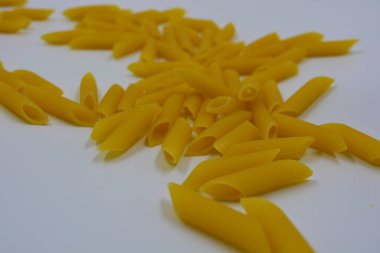 İtalyan sarısı makarna, erişte makarna, beyaz arka plana saçılmış buğday tüyü..