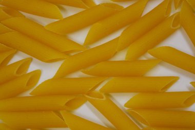 İtalyan sarısı makarna, erişte makarna, beyaz arka plana saçılmış buğday tüyü..